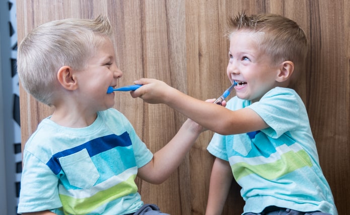 Two children playing with toothbrushes